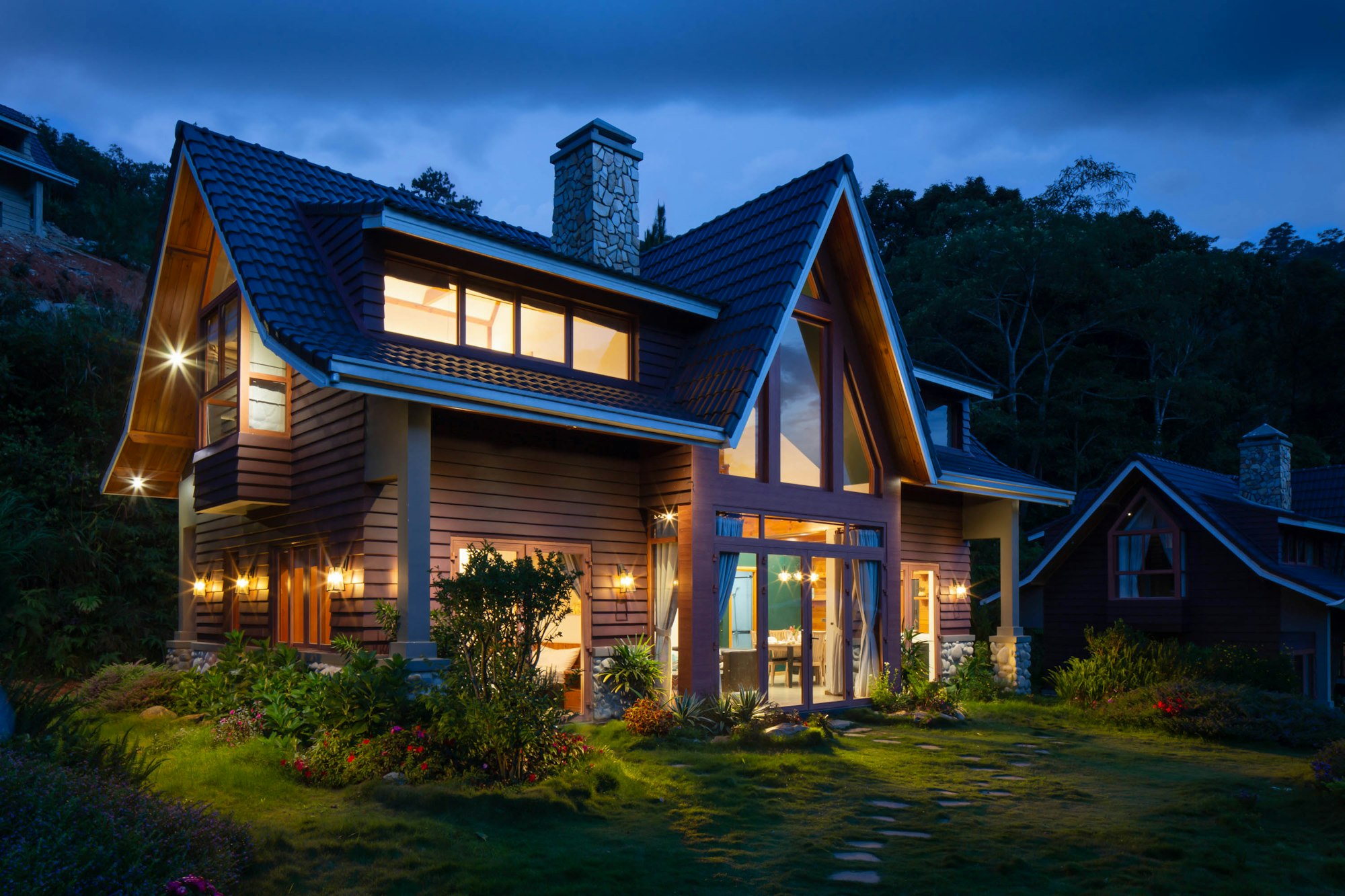 Craftsman-style home glowing at dusk in a wooded Raleigh-area setting