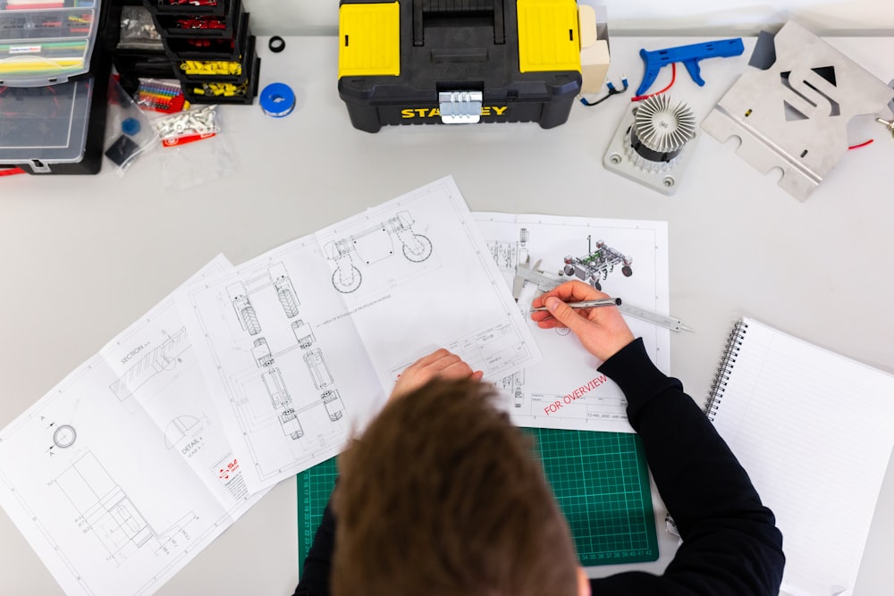 Inspector reviewing hand-drawn building plans at a workbench with tools