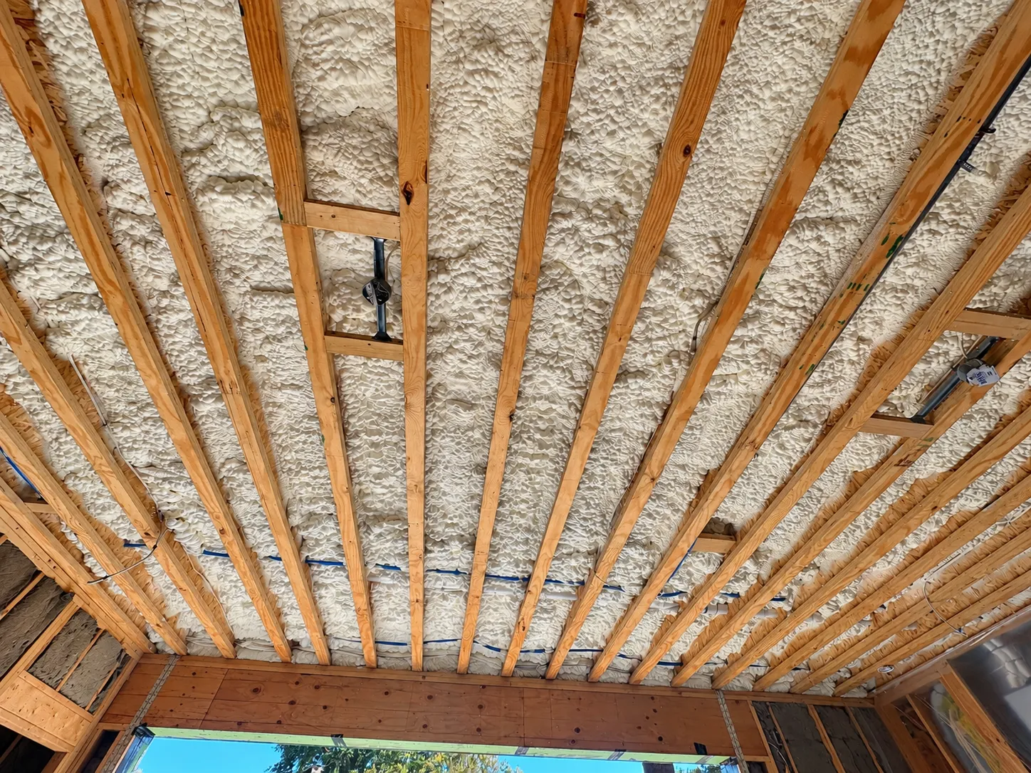 Spray-foam insulation between roof framing members